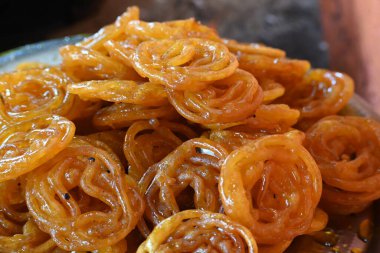 Jalebi tatlıları. Hindistan 'ın alt kıtasında popüler bir atıştırmalık. Birçok isim var; jilebi, jilipi, zulbia, mushabak, zlabia ve zalabia. Maida un ve şeker şurubu tarafından yapıldı..