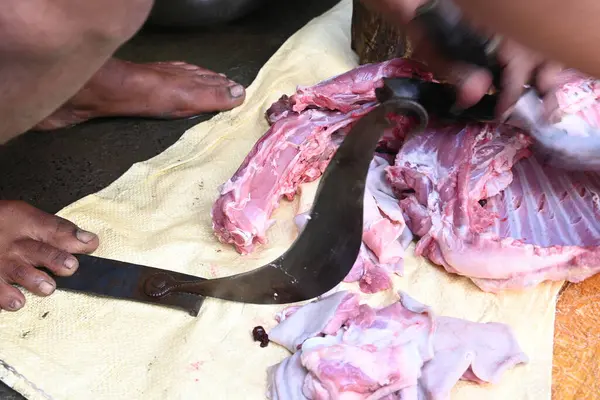 Keçi eti doğrama. Hint köyündeki geleneksel demir aletlerden taze çiğ ya da pişmemiş koyun eti. Keçi etini küçük parçalara ayırmak..