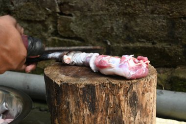 Tahtada keçi eti doğramak. Hint köyündeki geleneksel demir aletlerden taze çiğ ya da pişmemiş koyun eti. Keçi etini küçük parçalara ayırmak..