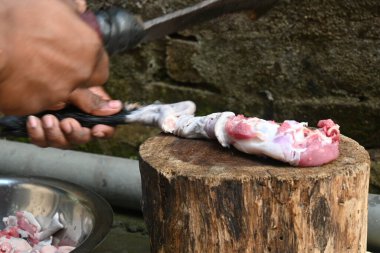 Tahtada keçi eti doğramak. Hint köyündeki geleneksel demir aletlerden taze çiğ ya da pişmemiş koyun eti. Keçi etini küçük parçalara ayırmak..