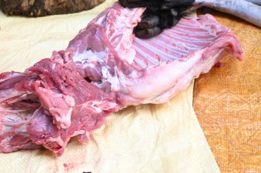 Taze çiğ ya da pişmemiş keçi eti. Geleneksel Hint köyünde koyun kesimi. Keçi etini parçalara ayırmak..