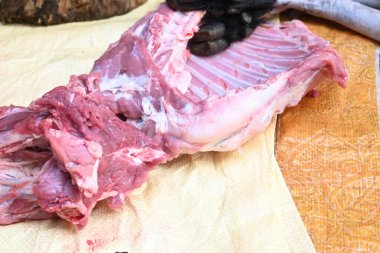 Taze çiğ ya da pişmemiş keçi eti. Geleneksel Hint köyünde koyun kesimi. Keçi etini parçalara ayırmak..