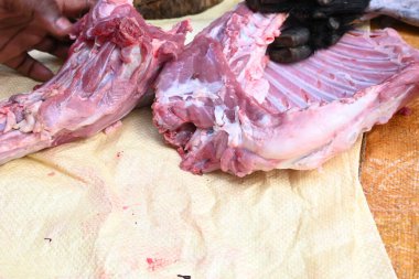 Taze çiğ ya da pişmemiş keçi eti. Geleneksel Hint köyünde koyun kesimi. Keçi etini parçalara ayırmak..