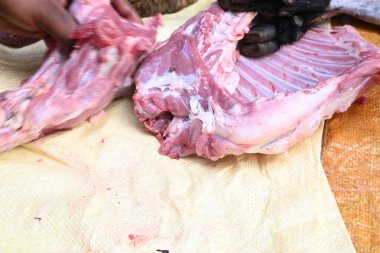 Taze çiğ ya da pişmemiş keçi eti. Geleneksel Hint köyünde koyun kesimi. Keçi etini parçalara ayırmak..