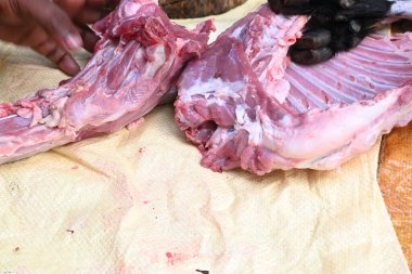 Taze çiğ ya da pişmemiş keçi eti. Geleneksel Hint köyünde koyun kesimi. Keçi etini parçalara ayırmak..