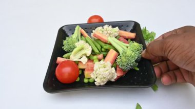 Canlı taze sebze karışımı. İçinde brokoli, karnabahar, domates, havuç, yeşil fasulye ve bezelye var. Bahar mevsiminin renkli sebzeleri, sağlık için iyidir. Renkli ekran.