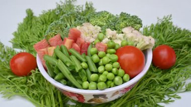 Canlı taze sebze karışımı. İçinde brokoli, karnabahar, domates, havuç, yeşil fasulye ve bezelye var. Bahar mevsiminin renkli sebzeleri, sağlık için iyidir. Renkli ekran.