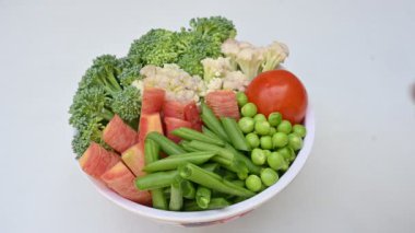 Canlı taze sebze karışımı. İçinde brokoli, karnabahar, domates, havuç, yeşil fasulye ve bezelye var. Bahar mevsiminin renkli sebzeleri, sağlık için iyidir. Renkli ekran.