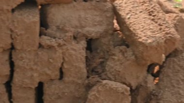 Çiğ kil tuğlalar suya batırılmış. Kurumuş çamur tuğlaları, yağmur suyunda ıslanarak mahvolmuş. Tuğla üretimi.