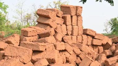 Çiğ kil tuğlalar suya batırılmış. Kurumuş çamur tuğlaları, yağmur suyunda ıslanarak mahvolmuş. Tuğla üretimi.