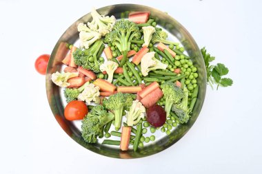 Canlı taze sebze karışımı. İçinde brokoli, karnabahar, domates, havuç, yeşil fasulye ve bezelye var. Bahar mevsiminin renkli sebzeleri, sağlık için iyidir. Renkli ekran.