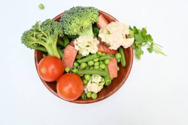 Canlı taze sebze karışımı. İçinde brokoli, karnabahar, domates, havuç, yeşil fasulye ve bezelye var. Bahar mevsiminin renkli sebzeleri, sağlık için iyidir. Renkli ekran.