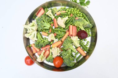 Canlı taze sebze karışımı. İçinde brokoli, karnabahar, domates, havuç, yeşil fasulye ve bezelye var. Bahar mevsiminin renkli sebzeleri, sağlık için iyidir. Renkli ekran.