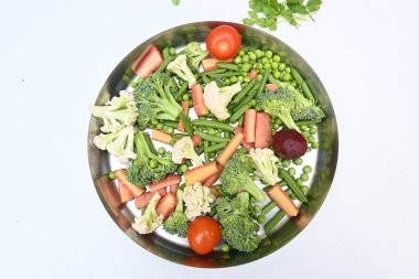 Canlı taze sebze karışımı. İçinde brokoli, karnabahar, domates, havuç, yeşil fasulye ve bezelye var. Bahar mevsiminin renkli sebzeleri, sağlık için iyidir. Renkli ekran.