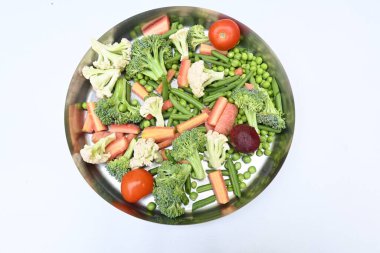 Canlı taze sebze karışımı. İçinde brokoli, karnabahar, domates, havuç, yeşil fasulye ve bezelye var. Bahar mevsiminin renkli sebzeleri, sağlık için iyidir. Renkli ekran.