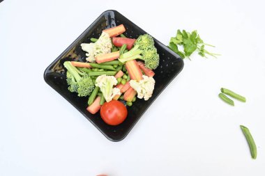 Canlı taze sebze karışımı. İçinde brokoli, karnabahar, domates, havuç, yeşil fasulye ve bezelye var. Bahar mevsiminin renkli sebzeleri, sağlık için iyidir. Renkli ekran.