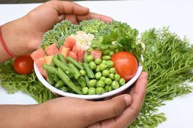 Canlı taze sebze karışımı. İçinde brokoli, karnabahar, domates, havuç, yeşil fasulye ve bezelye var. Bahar mevsiminin renkli sebzeleri, sağlık için iyidir. Renkli ekran.