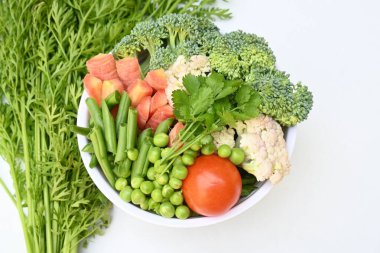 Canlı taze sebze karışımı. İçinde brokoli, karnabahar, domates, havuç, yeşil fasulye ve bezelye var. Bahar mevsiminin renkli sebzeleri, sağlık için iyidir. Renkli ekran.