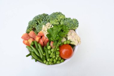 Canlı taze sebze karışımı. İçinde brokoli, karnabahar, domates, havuç, yeşil fasulye ve bezelye var. Bahar mevsiminin renkli sebzeleri, sağlık için iyidir. Renkli ekran.