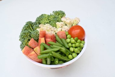 Canlı taze sebze karışımı. İçinde brokoli, karnabahar, domates, havuç, yeşil fasulye ve bezelye var. Bahar mevsiminin renkli sebzeleri, sağlık için iyidir. Renkli ekran.