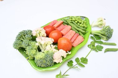 Canlı taze sebze karışımı. İçinde brokoli, karnabahar, domates, havuç, yeşil fasulye ve bezelye var. Bahar mevsiminin renkli sebzeleri, sağlık için iyidir. Renkli ekran.