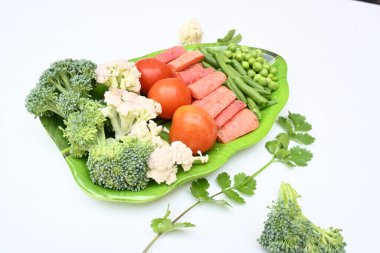 Canlı taze sebze karışımı. İçinde brokoli, karnabahar, domates, havuç, yeşil fasulye ve bezelye var. Bahar mevsiminin renkli sebzeleri, sağlık için iyidir. Renkli ekran.