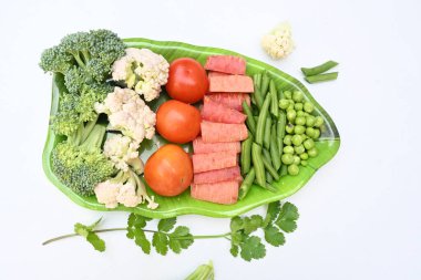 Canlı taze sebze karışımı. İçinde brokoli, karnabahar, domates, havuç, yeşil fasulye ve bezelye var. Bahar mevsiminin renkli sebzeleri, sağlık için iyidir. Renkli ekran.