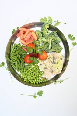 Canlı taze sebze karışımı. İçinde brokoli, karnabahar, domates, havuç, yeşil fasulye ve bezelye var. Bahar mevsiminin renkli sebzeleri, sağlık için iyidir. Renkli ekran.