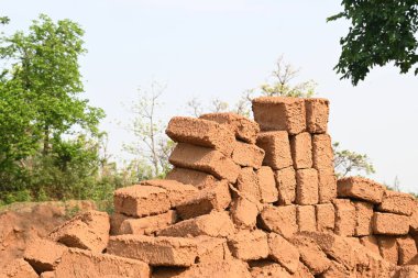 Çiğ kil tuğlalar suya batırılmış. Kurumuş çamur tuğlaları, yağmur suyunda ıslanarak mahvolmuş. Tuğla üretimi.