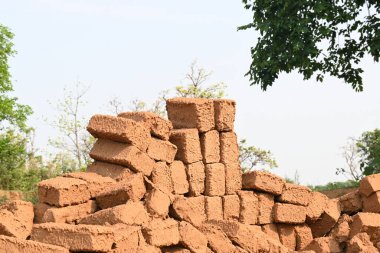 Çiğ kil tuğlalar suya batırılmış. Kurumuş çamur tuğlaları, yağmur suyunda ıslanarak mahvolmuş. Tuğla üretimi.