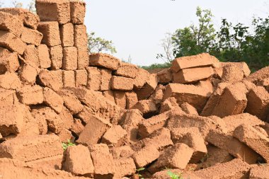 Çiğ kil tuğlalar suya batırılmış. Kurumuş çamur tuğlaları, yağmur suyunda ıslanarak mahvolmuş. Tuğla üretimi.