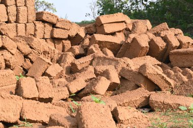 Çiğ kil tuğlalar suya batırılmış. Kurumuş çamur tuğlaları, yağmur suyunda ıslanarak mahvolmuş. Tuğla üretimi.
