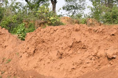 Toprak yığını. Toprak çıkarıldı ve kil tuğla haline getirildi. Doğal ortamda kırmızı toprak.