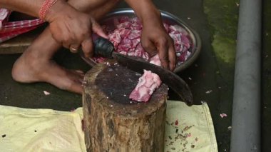 Keçi eti doğrama. Hint köyündeki geleneksel demir aletlerden taze çiğ ya da pişmemiş koyun eti. Keçi etini küçük parçalara ayırmak. Yavaş çekim videosu. 