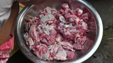 Keçi eti doğrama. Hint köyündeki geleneksel demir aletlerden taze çiğ ya da pişmemiş koyun eti. Keçi etini küçük parçalara ayırmak. Yavaş çekim videosu. 