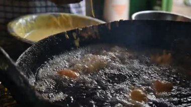 Aloo Chop büyük demir tavayı kızartıyor. Hindistan 'ın haşlanmış patatesten, çeşitli baharatlardan ve gram undan oluşan altkıtasından gelen kortizon. Hindistan 'ın birçok eyaletinde mevcut. Yavaş çekim 