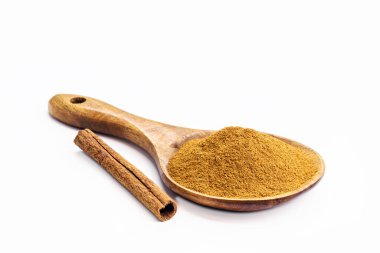 Tarçın tozu ve tarçın çubuğu kırsal ahşap kaşıkta, izole edilmiş beyaz arka plan ve fotokopi alanı, noel şekeri mutfak malzemeleri
