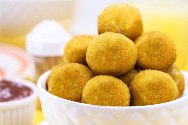 Tipik Brezilya böreği, yağda kızartılmış, peynir, kasava, mısır, mısır, mısır veya aipin aromalı, çıtır çıtır ve yuvarlak hamur köftesi ile sıcak servis edilir..