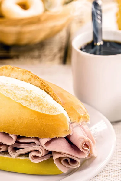 stock image typical brazilian snack, po de sal with slices of mozzarella cheese and ham, french bread for breakfast with hot coffee.