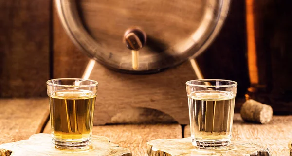 Glass of golden rum, with bottle. Bottle pouring alcohol into a small glass. Brazilian export type drink. Brazilian product for export, distilled drink known as brandy or pinga. Day of cachaca.