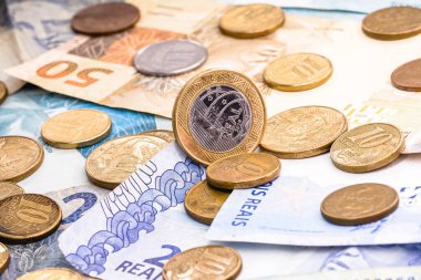 Çeşitli Brezilya banknotları, çeşitli değerlerde paralar, kirli ve yerde yatıyor. Düzensiz finans veya mali kriz kavramı