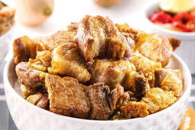 Domuz eti, kızarmış domuz pastırması, lezzetli domuz eti, tipik Brezilya aperatifi, arka planda cachaca, Minas Gerais 'den geleneksel yemekler.