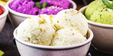 Arkaplanda tropikal meyveler, çilek, muz, jabuticaba ve avokado aromalı organik meyvelerden yapılmış vejetaryen dondurması.