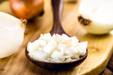 Kırsal ahşap kaşık, doğranmış ve parçalanmış soğan, klasik kırsal mutfak, baharat malzemeleri hazırlanıyor.