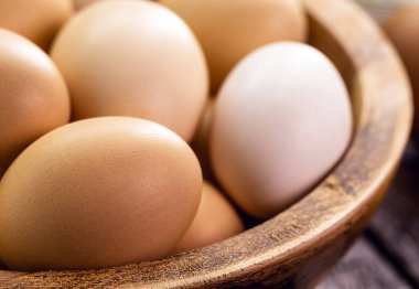 El yapımı ahşap kâse içinde serbest tavuk yumurtası, organik köy mutfağı.