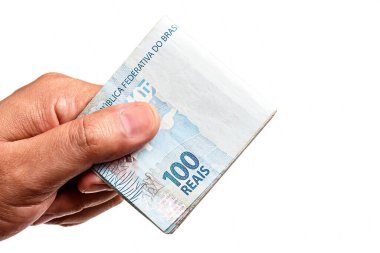 Brezilya 'dan gelen 100 reais banknotun el ele tutuşması, izole edilmiş beyaz arka planda. Banka taslak veya mali kar kavramı