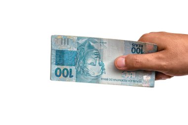 hand holding Brazilian money banknotes, 100 Brazilian real notes, concept of payment, prize or lottery. Isolated white background