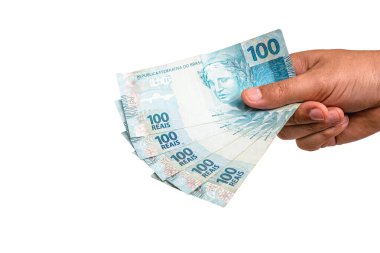 hand holding Brazilian money banknotes, 100 Brazilian real notes, concept of payment, prize or lottery. Isolated white background
