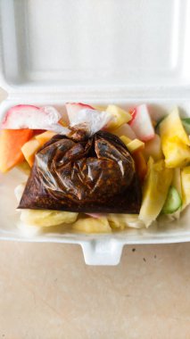 Rujak, tatlı ve baharatlı taze meyve karışımıdır. Tabakta servis edilir.