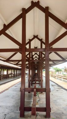 Ahşap sütunlu çatısı olan bir motosiklet parkı.